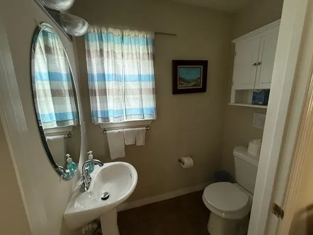 a bathroom with a toilet sink and mirror