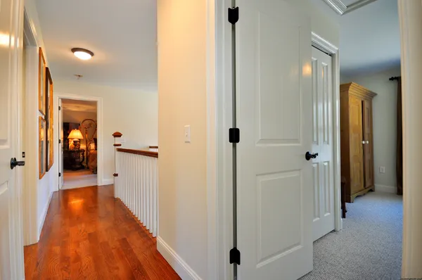 a view of a hallway with wooden floor and a living room