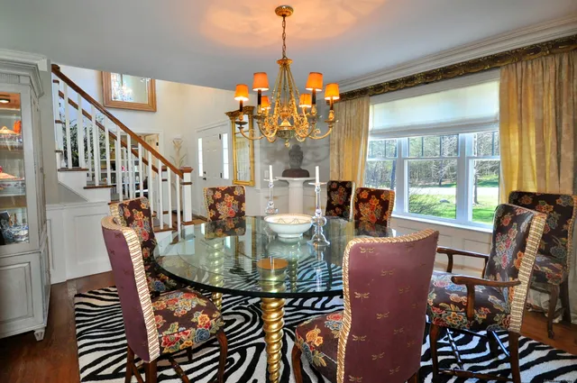a dining room with furniture large windows chandeliers and wooden floor