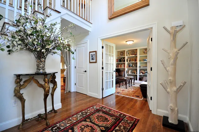 an entryway with wooden floor and a rug