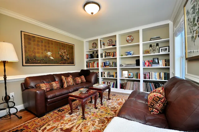 a living room with furniture and a book shelf