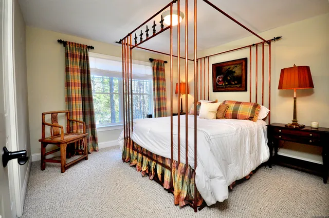 a bedroom with a bed and a lamp with window