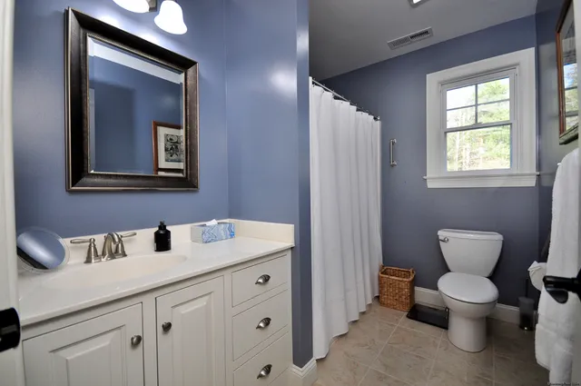 a bathroom with a toilet sink and mirror