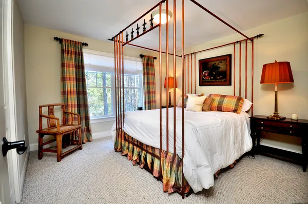 a bedroom with a bed and a lamp with window