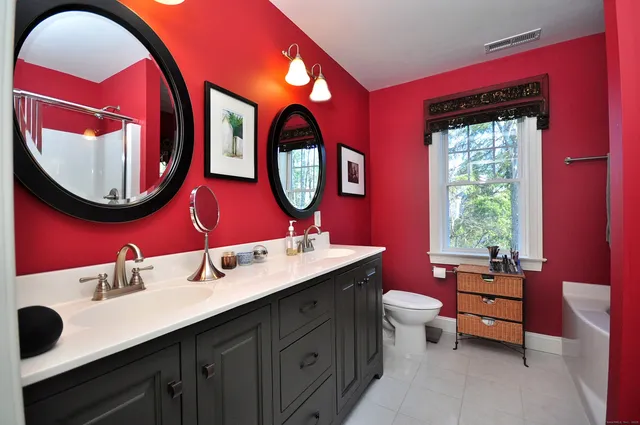 a bathroom with a toilet a sink and a mirror