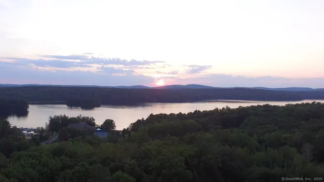 a view of a lake in middle of the house with a yard and lake view