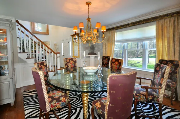 a dining room with furniture large windows chandeliers and wooden floor