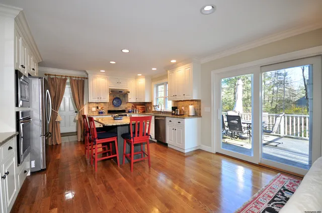 a kitchen with a table chairs refrigerator and microwave