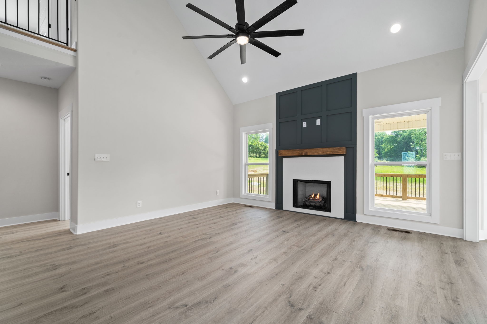 1045 Gratton Road Clarksville, TN 37043 - Photo 4 of 38 an empty room with windows a fireplace a ceiling fan and wooden floor