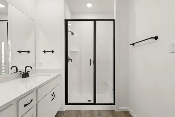 a bathroom with a shower sink and mirror