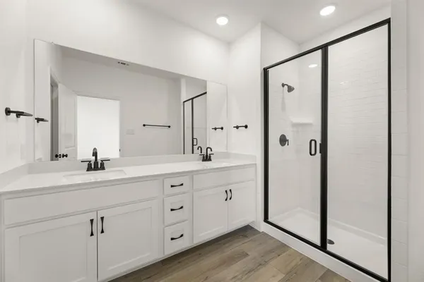 a bathroom with a double vanity sink mirror and shower