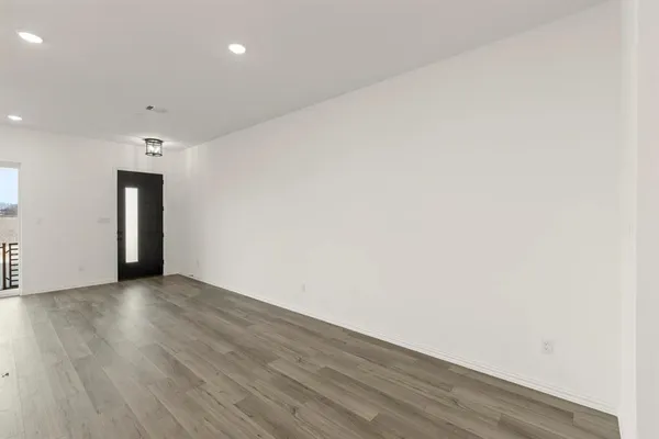 a view of an empty room with wooden floor