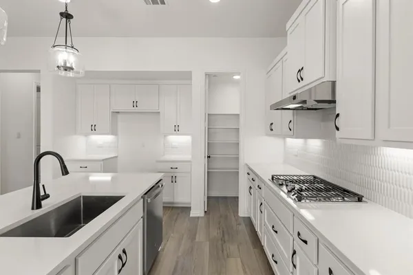 a kitchen with stainless steel appliances a sink a stove and a refrigerator