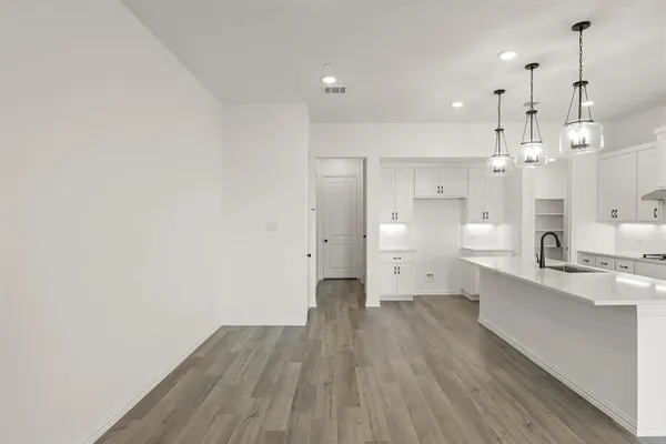 a view of a kitchen with wooden floor and windows