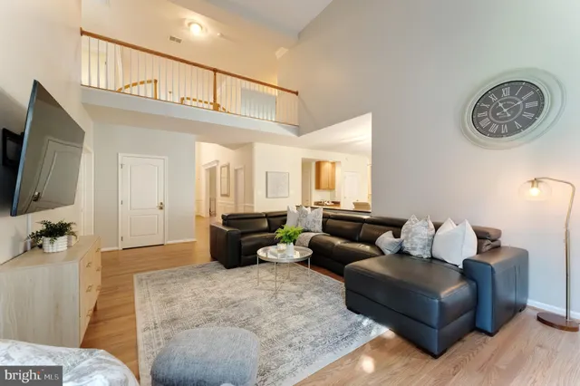 a kitchen with stainless steel appliances granite countertop a stove refrigerator a dining table and chairs with wooden floor