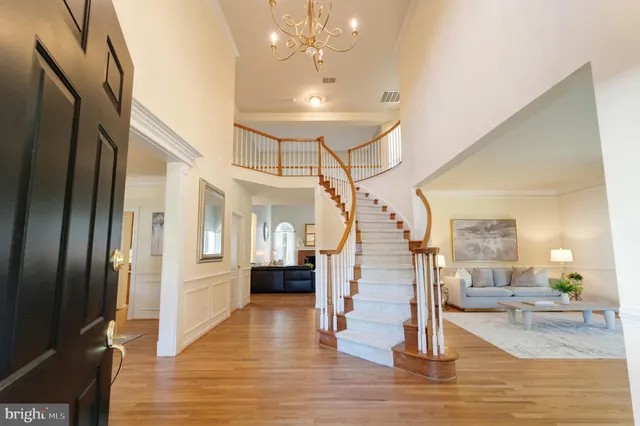 a view of a hallway with stairs and wooden floor