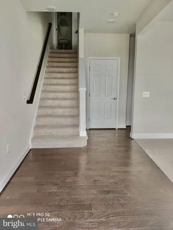a view of a hallway with wooden floor and stairs