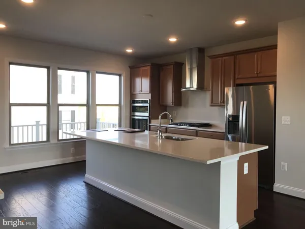 a kitchen with stainless steel appliances granite countertop a sink a stove and refrigerator