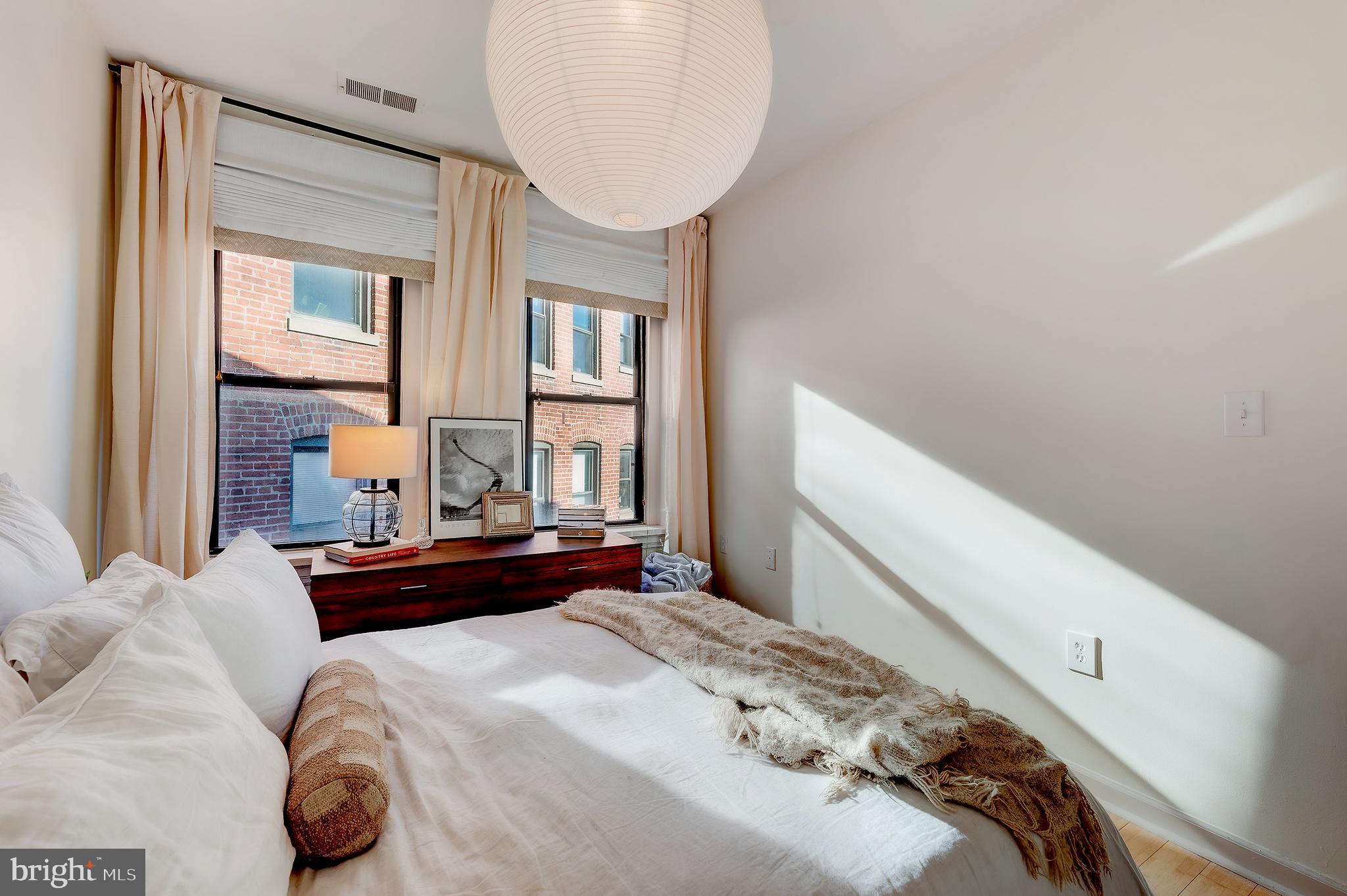 1918 18th Street Northwest, Unit 42 Washington, DC 20009 - Photo 14 of 22 a bedroom with a bed and a chandelier