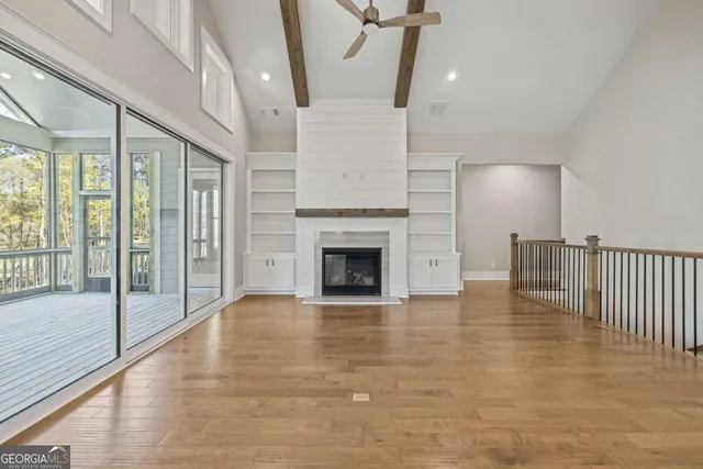 a view of a livingroom with a fireplace wooden floor and window