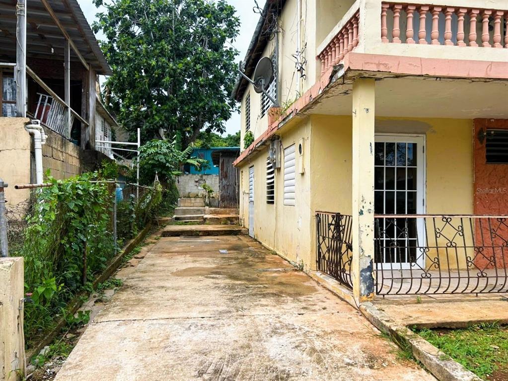 5 Calle Barceloneta, PR 00617 - Photo 3 of 40 a view of a pathway of a house with a small yard and stairs