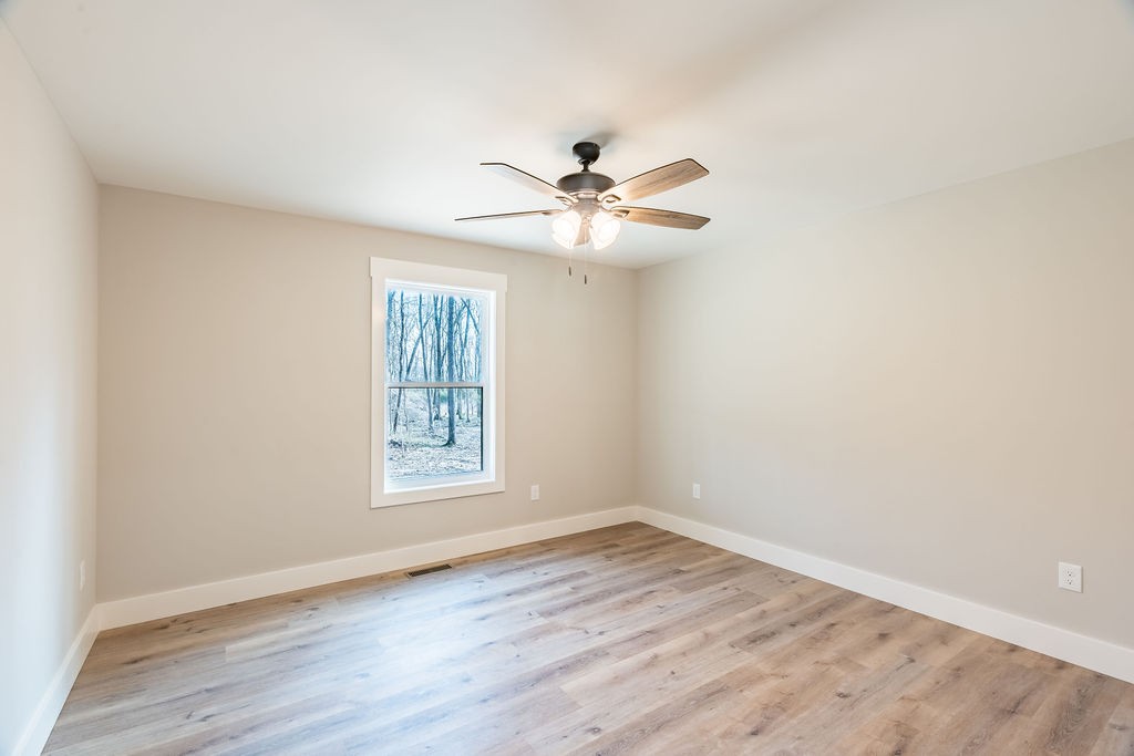351 Chesnut Road Guthrie, KY 42234 - Photo 18 of 30 an empty room with wooden floor ceiling fan and windows