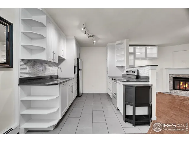 a kitchen with stainless steel appliances kitchen island granite countertop a stove a sink and a refrigerator