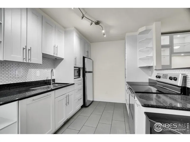 a kitchen with granite countertop a sink stainless steel appliances and cabinets