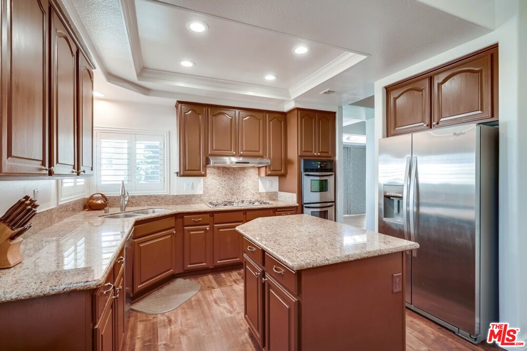 32377 Corte Santa Catalina Temecula, CA 92592 - Photo 7 of 27 a kitchen with granite countertop stainless steel appliances a sink stove refrigerator and cabinets