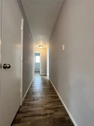 a view of a hallway with wooden floor