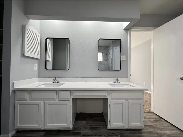 a bathroom with a double vanity sink and two mirror