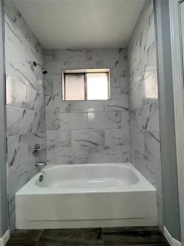 a bathroom with a bathtub and shower