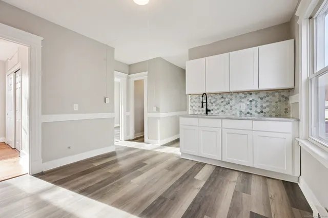 a kitchen with granite countertop a refrigerator and a stove top oven