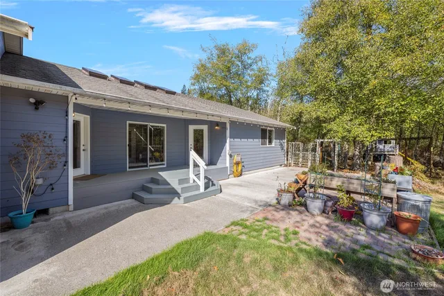 a view of a patio with table and chairs potted plants and a large tree