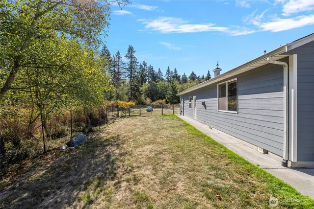 a view of a house with palm trees and a big yard