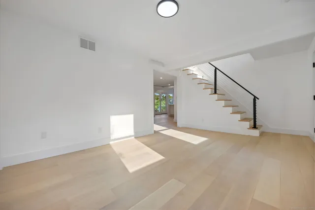 a view of an empty room with stairs and a window