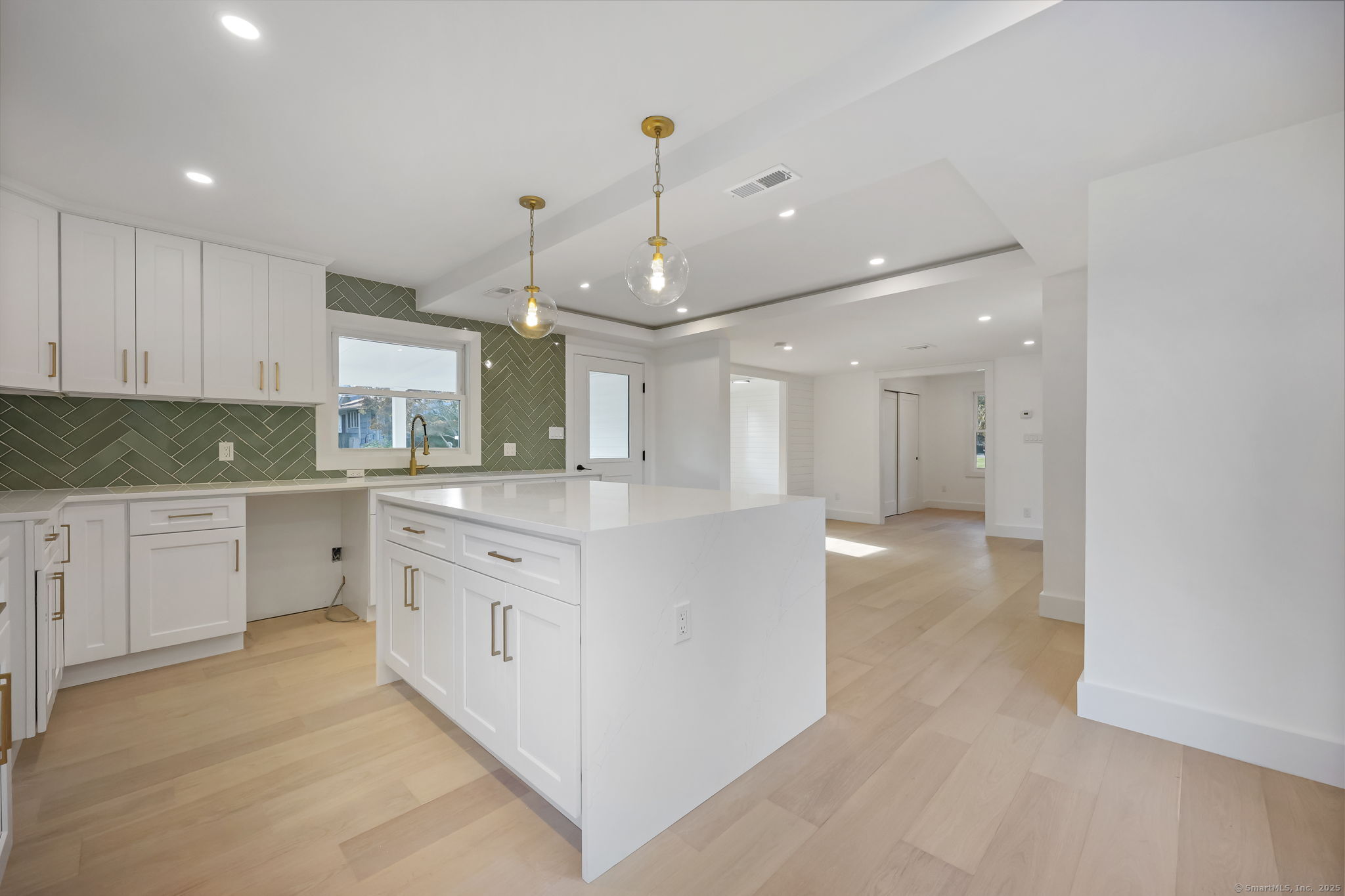 294 Thimble Island Road Branford, CT 06405 - Photo 10 of 39 a large kitchen with granite countertop a white stove top oven and white cabinets