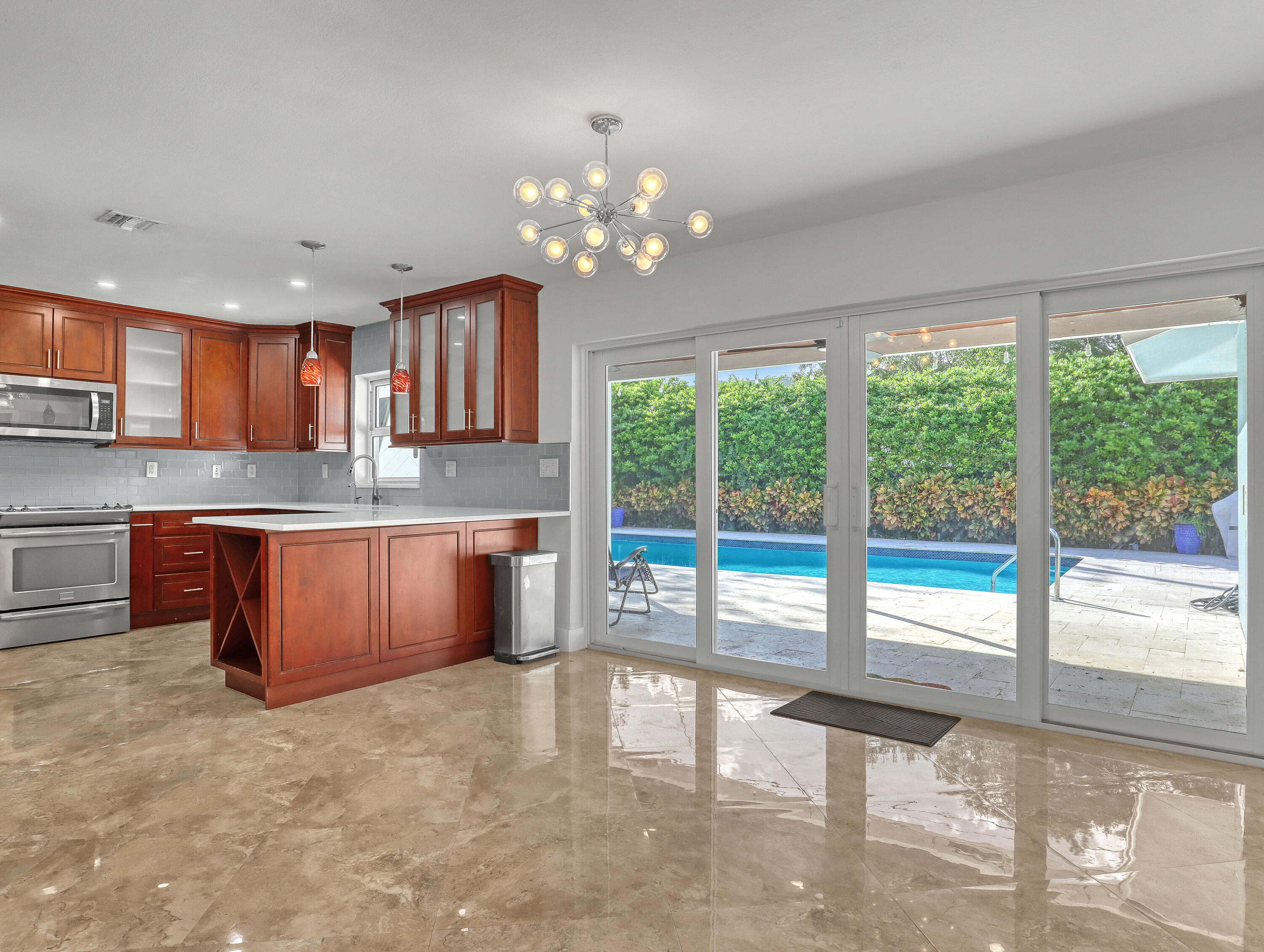 a large kitchen with kitchen island granite countertop wooden cabinets a granite counter tops and a large window