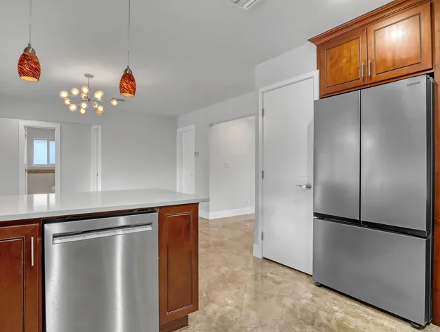 a view of a refrigerator in kitchen and an empty room