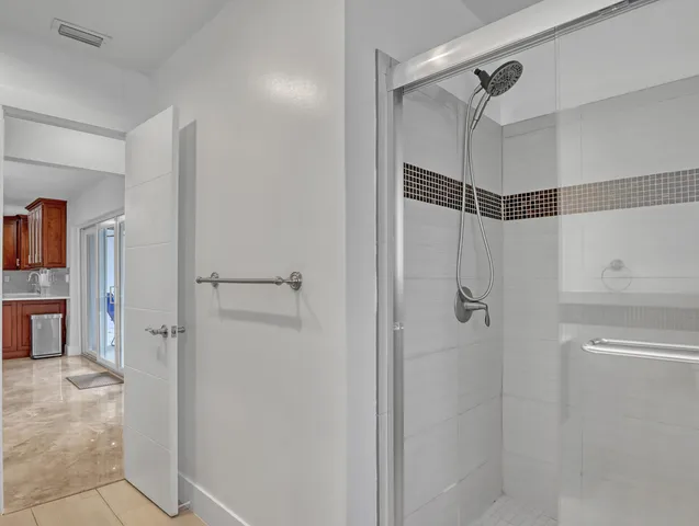 a bathroom with a shower and a glass door