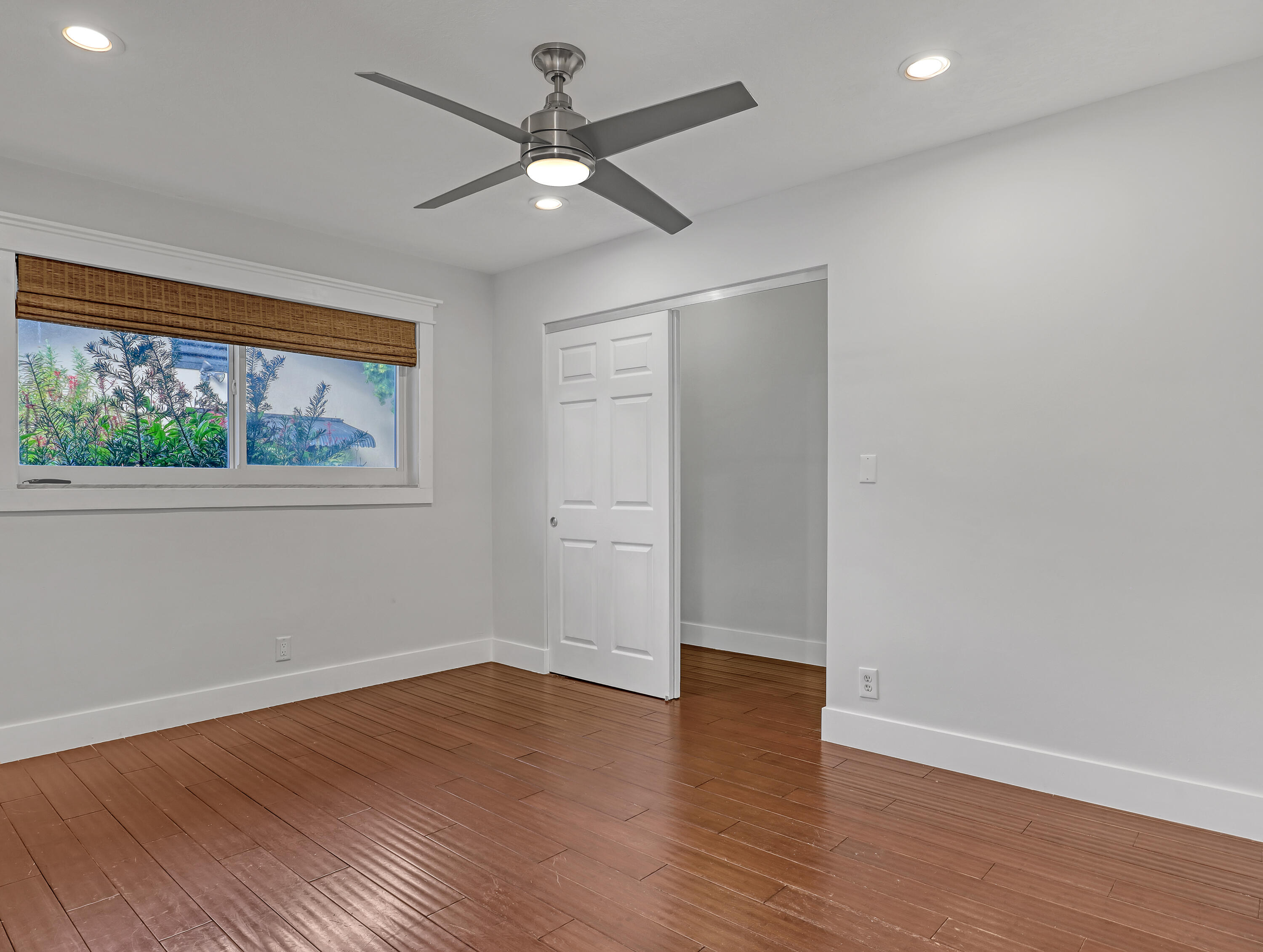 1298 Northwest 4th Street Boca Raton, FL 33486 - Photo 24 of 36 an empty room with wooden floor chandelier fan and windows