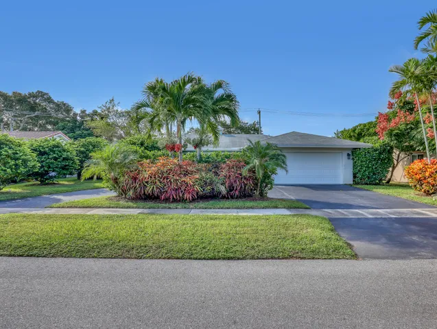 a front view of a house with a garden and yard