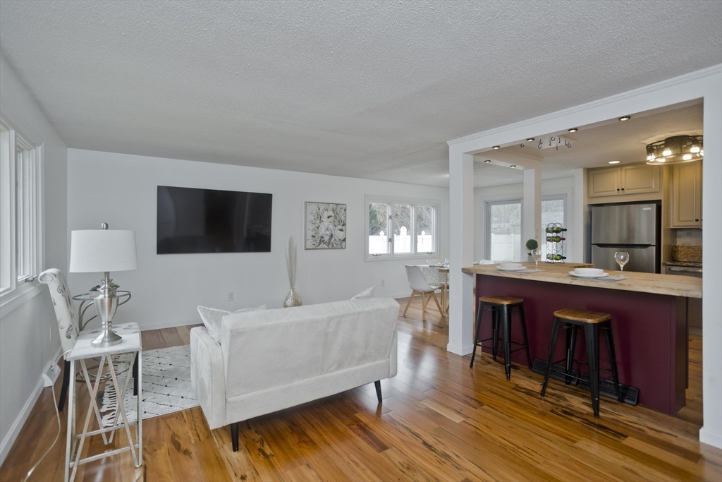 76 Paulk Terrace Springfield, MA 01128 - Photo 16 of 26 a living room with furniture a flat screen tv and kitchen view