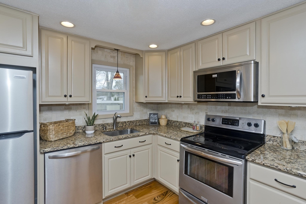 76 Paulk Terrace Springfield, MA 01128 - Photo 4 of 26 a kitchen with granite countertop white cabinets stainless steel appliances and a sink