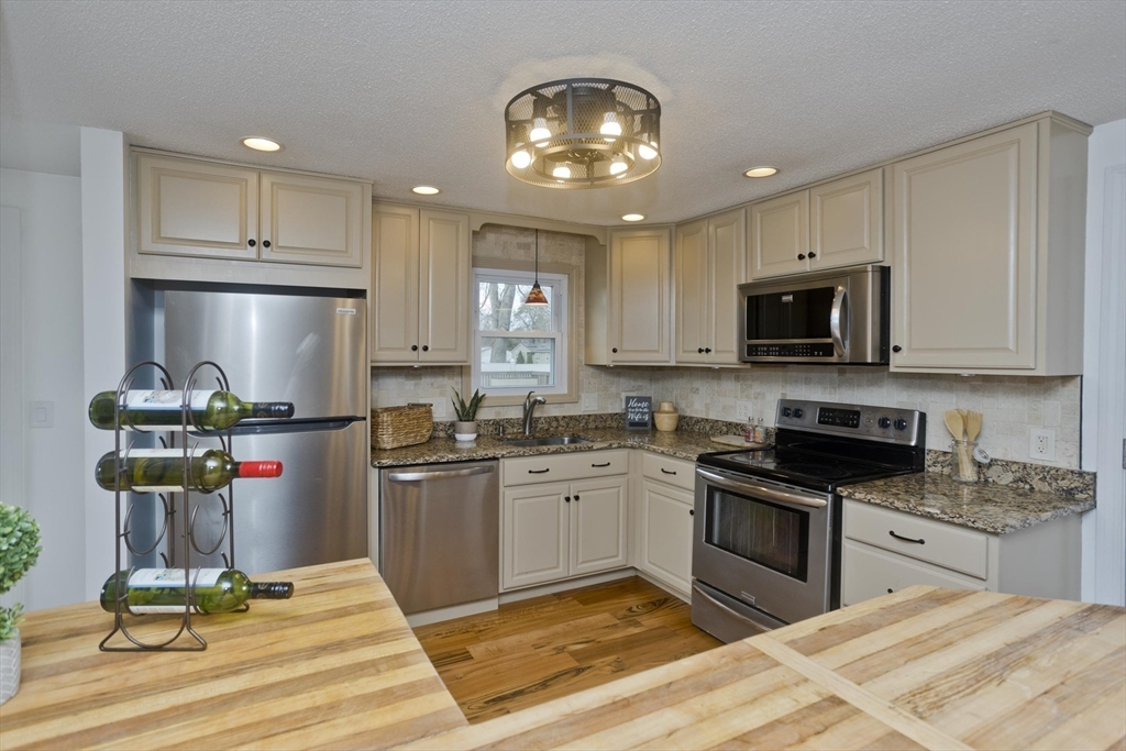 76 Paulk Terrace Springfield, MA 01128 - Photo 5 of 26 a kitchen with stainless steel appliances kitchen island granite countertop a stove and cabinets
