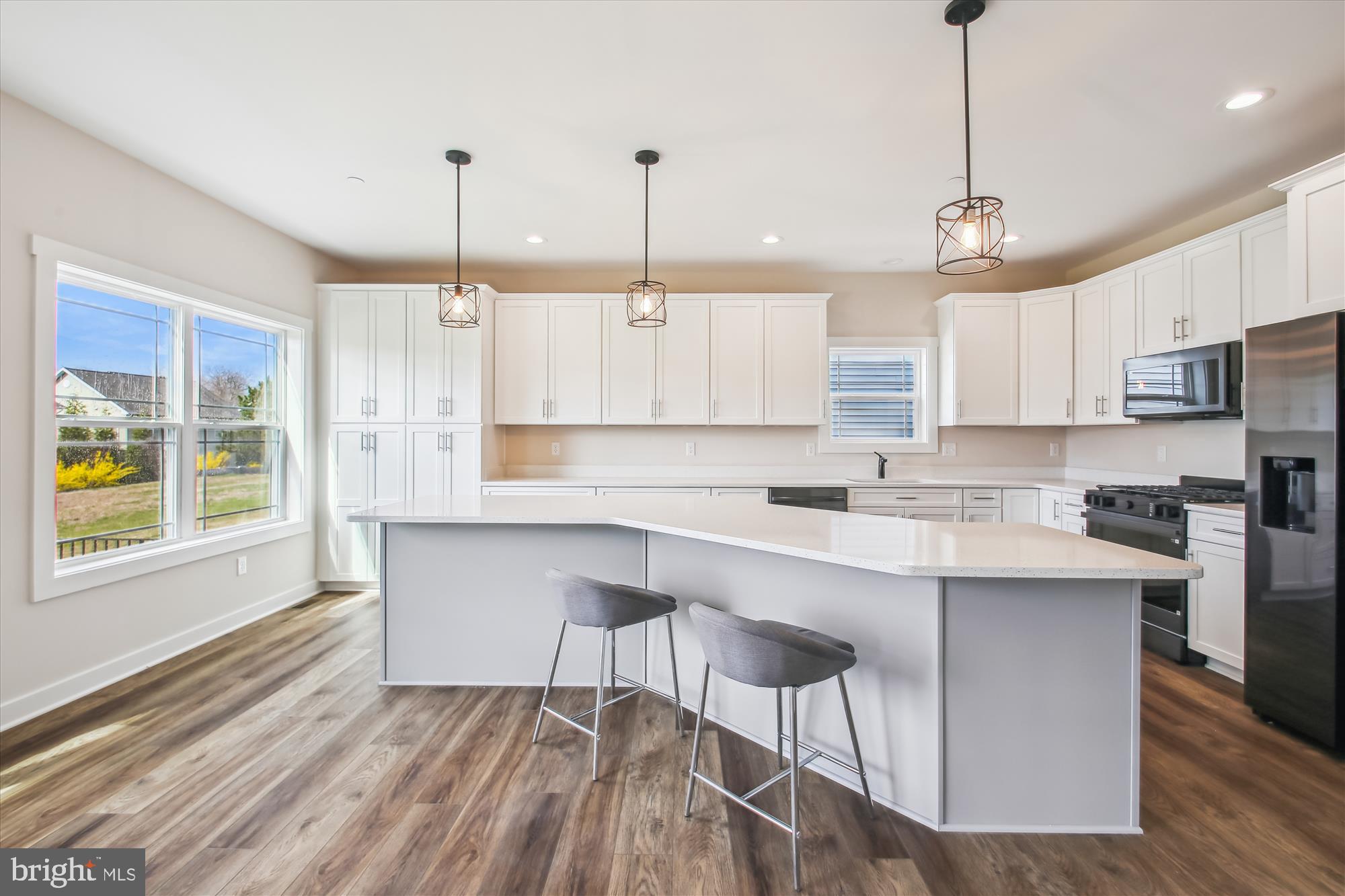 a kitchen with kitchen island granite countertop a sink a center island a counter space and a window
