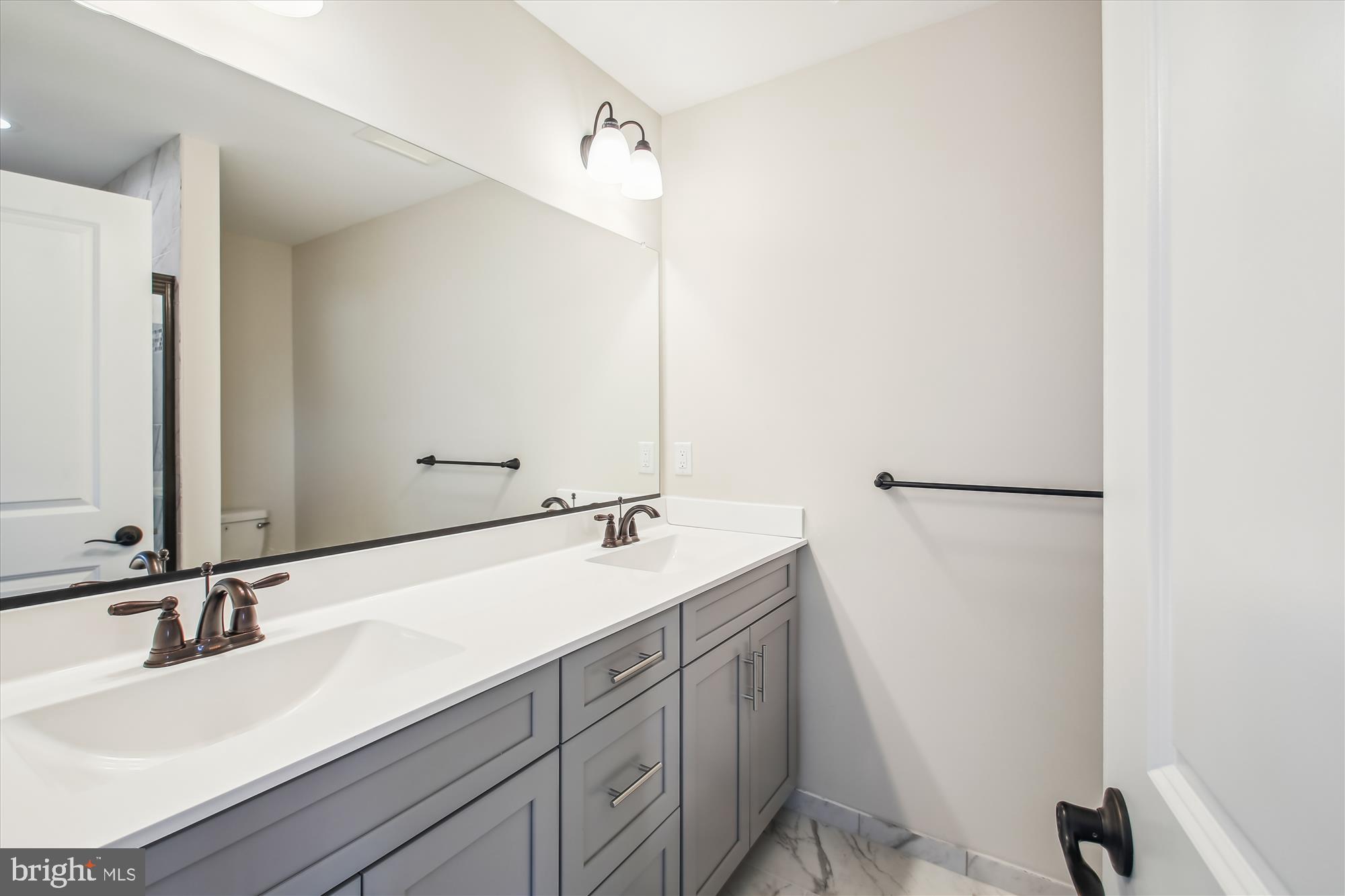509 South Farm Crossing Road Severn, MD 21144 - Photo 23 of 35 a bathroom with a double vanity sink and mirror