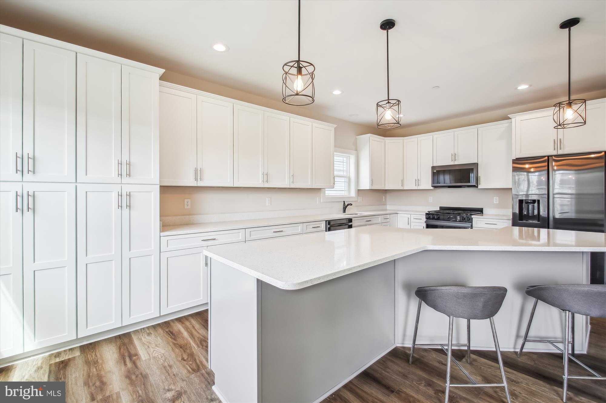 509 South Farm Crossing Road Severn, MD 21144 - Photo 4 of 35 a kitchen with stainless steel appliances granite countertop a sink a stove a refrigerator and island with wooden floor