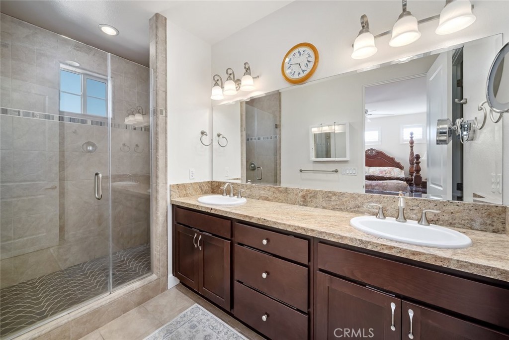 1187 Swallowtail Way Nipomo, CA 93444 - Photo 18 of 59 a bathroom with a granite countertop sink a mirror and a shower