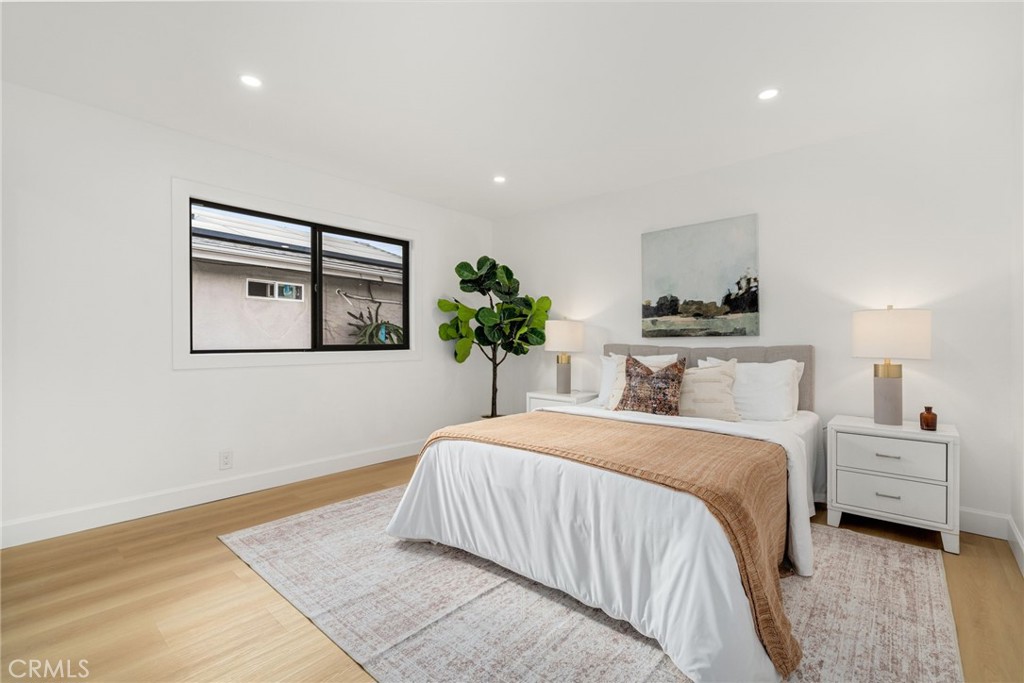 6072 Navajo Road Westminster, CA 92683 - Photo 16 of 26 a bedroom with a large bed and a potted plant